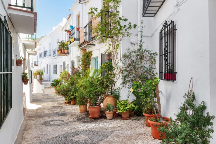 Picturesque narrow street decorated with plants. Frigiliana, Andalusia, Spain