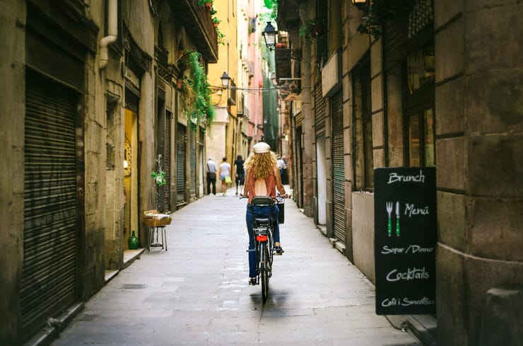 Riding bicycle through old street of Barcelona
