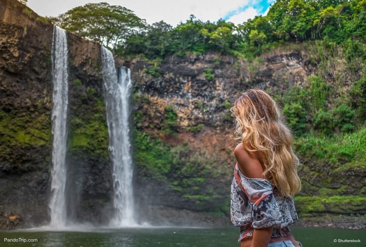 Beautiful woman looking at Wailua Falls, Kauai, Hawaii