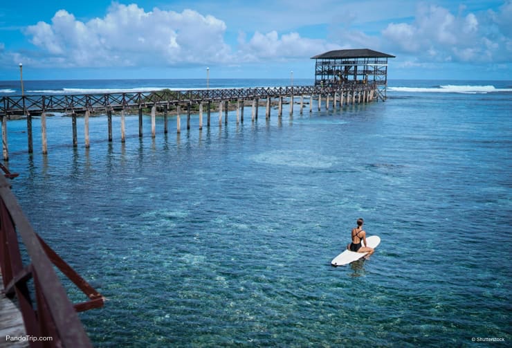 Woman surfing on Siargao island, Philippines