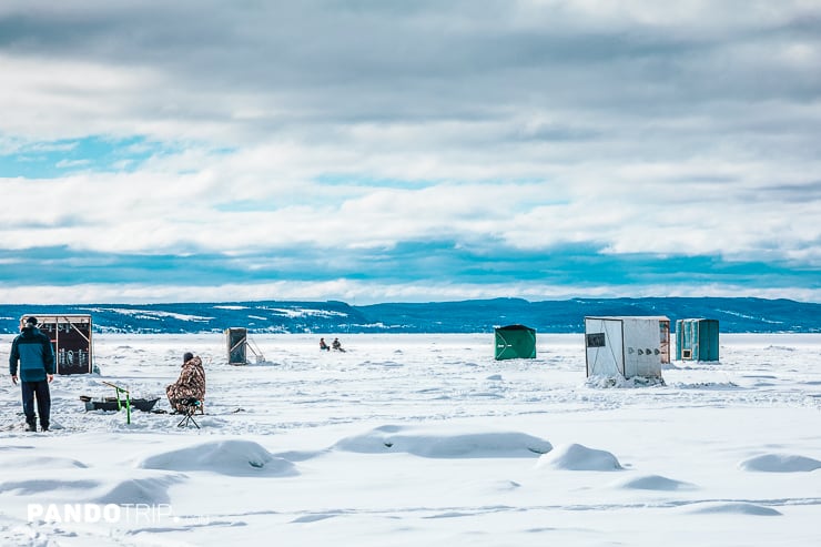 Scenic view of fishing shacks on a frozen lake in the Canadian wilderness