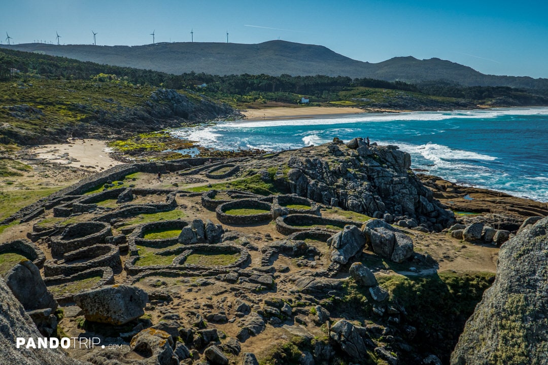 Ancient circular stone dwellings of Castro de Baroña on a windswept headland