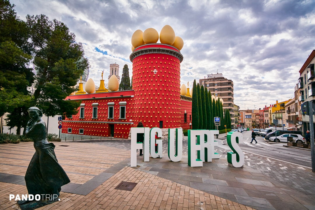 Exterior view of the red façade and rooftop eggs of the Dalí Theatre-Museum in Figueres, Spain