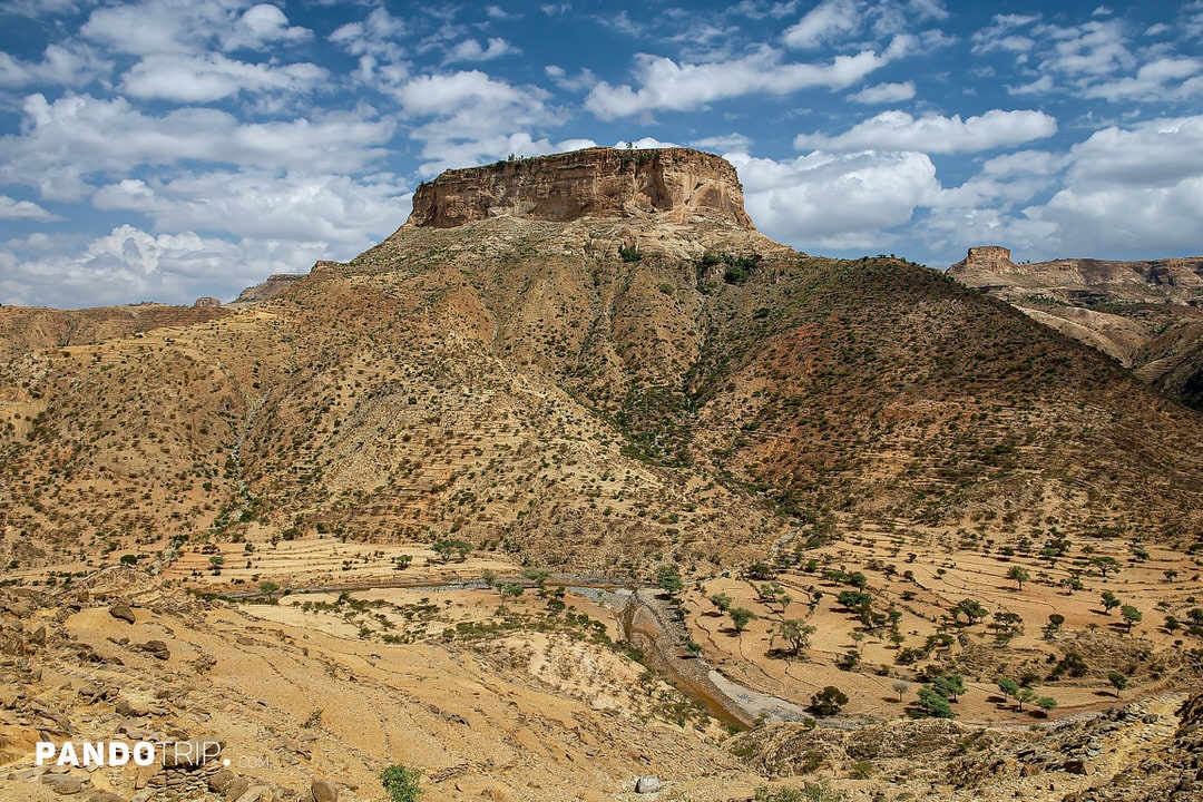 Debre Damo’s flat-topped mountain surrounded by rugged terrain in northern Ethiopia`