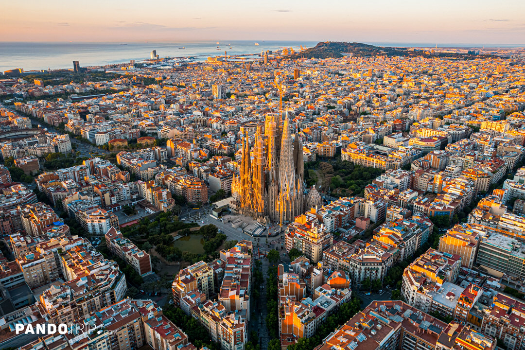 Aerial view of the Sagrada Família basilica surrounded by the Eixample grid of Barcelona.