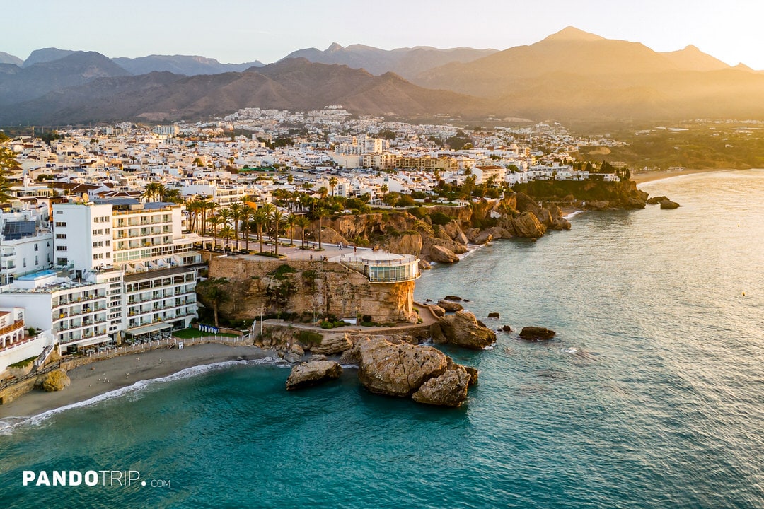 Aerial view of Nerja with the Balcón de Europa and mountains in the background at sunset, Costa del Sol