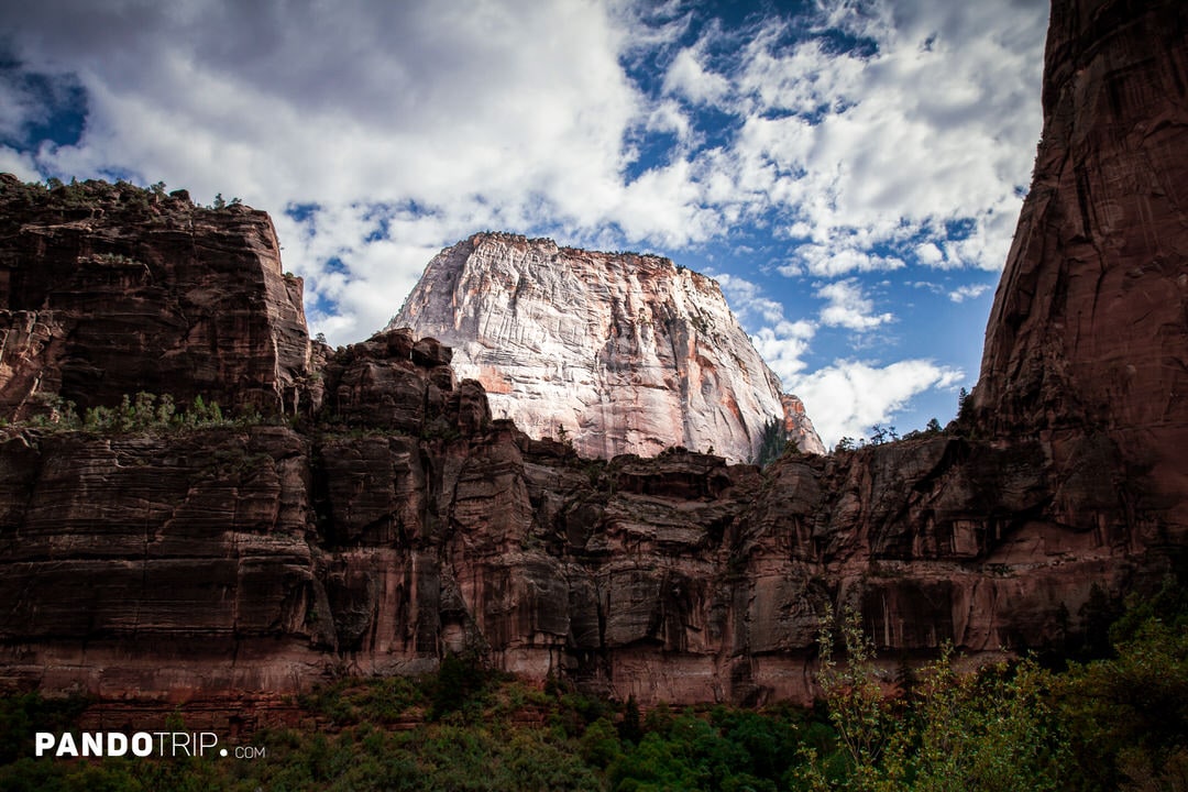 The Great White Throne rises above the canyon, framed by dark rock walls and a cloudy sky in Zion National Park
