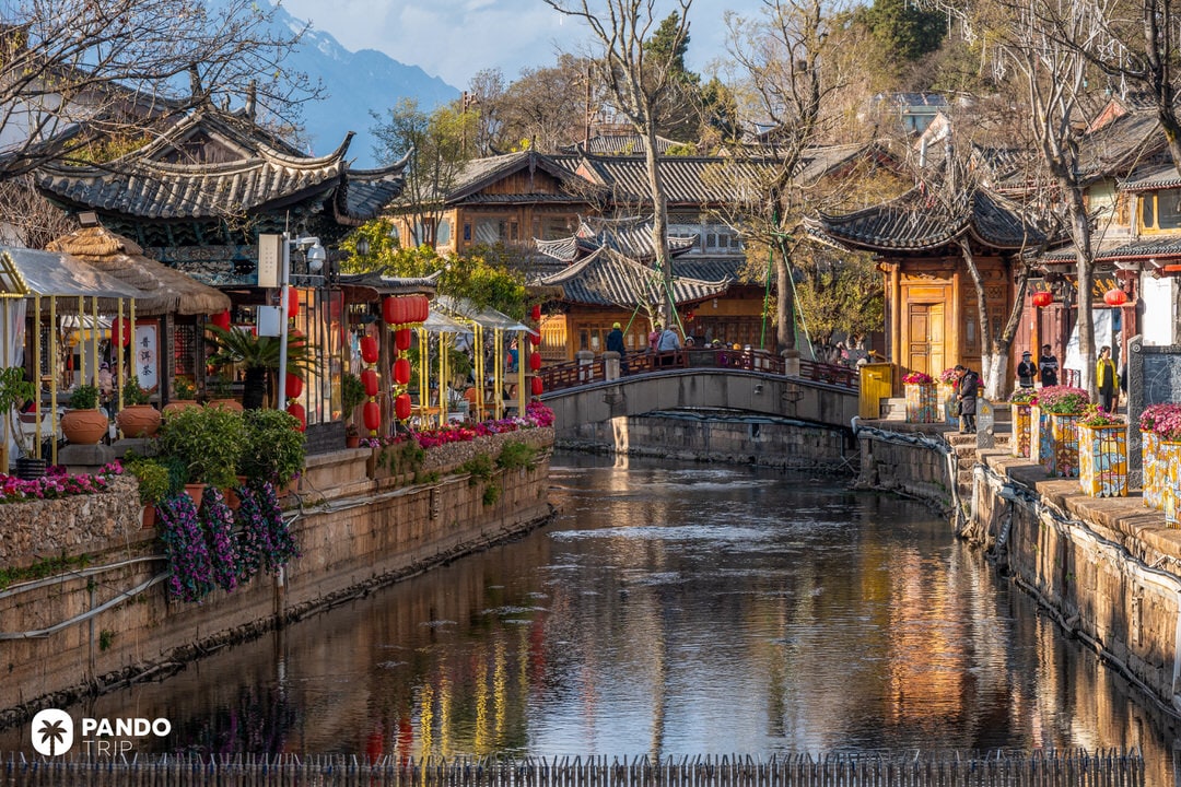 Charming canal-side view in Lijiang Old Town with red lanterns, bridges, and tea houses
