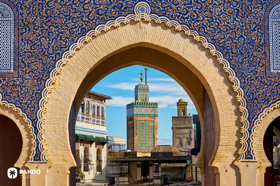 Intricate view of the Blue Gate arch framing mosque minarets in the old medina of Fes el-Bali