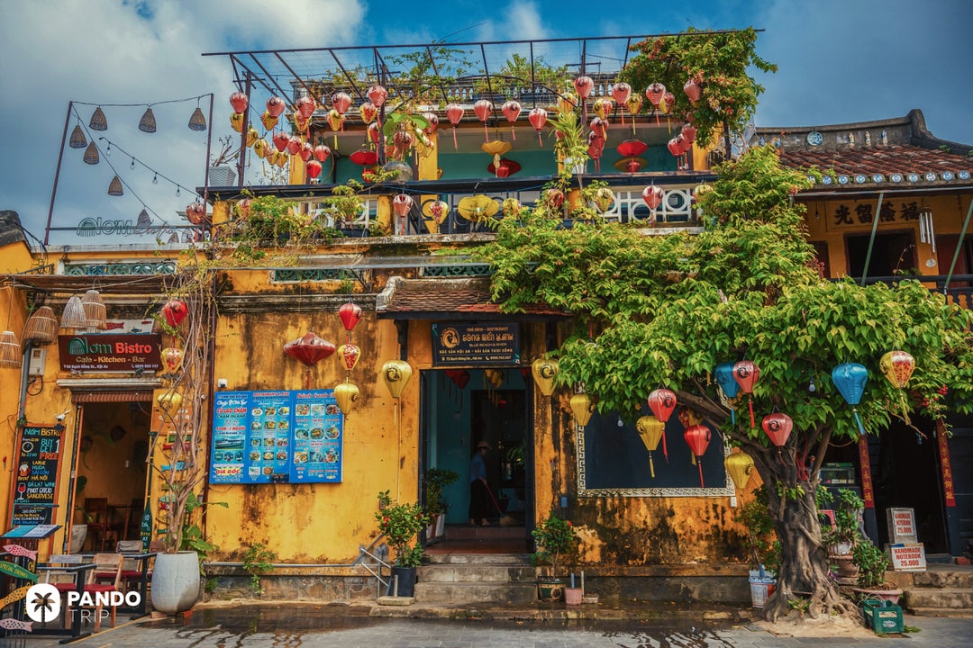 Colorful paper lanterns decorating a yellow colonial house in the old town of Hoi An, Vietnam
