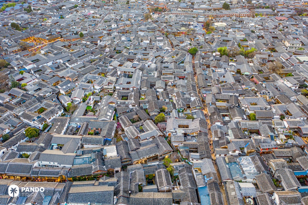 Drone view of Lijiang Old Town’s dense rooftops and narrow traditional alleyways