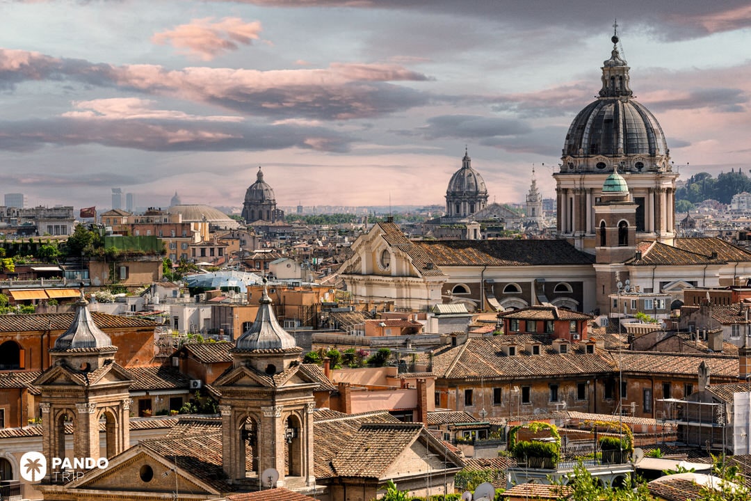 View over Rome’s rooftops with Baroque church domes and terracotta tiles at sunset