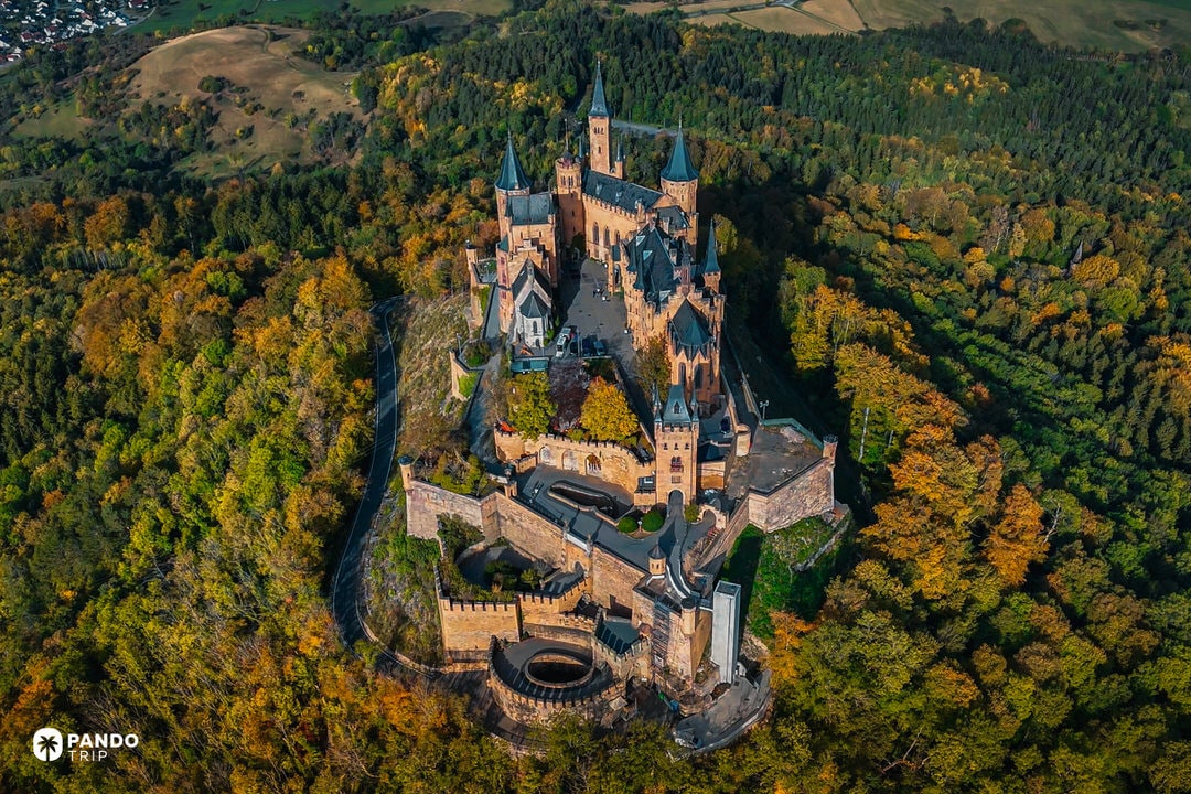 Bird’s-eye view of Hohenzollern Castle crowning a forested peak in Baden-Württemberg.