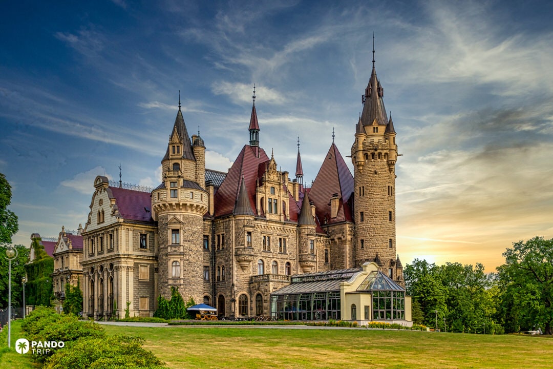 Eclectic Moszna Castle with 99 turrets and mixed Baroque, Gothic wings under a dramatic sky