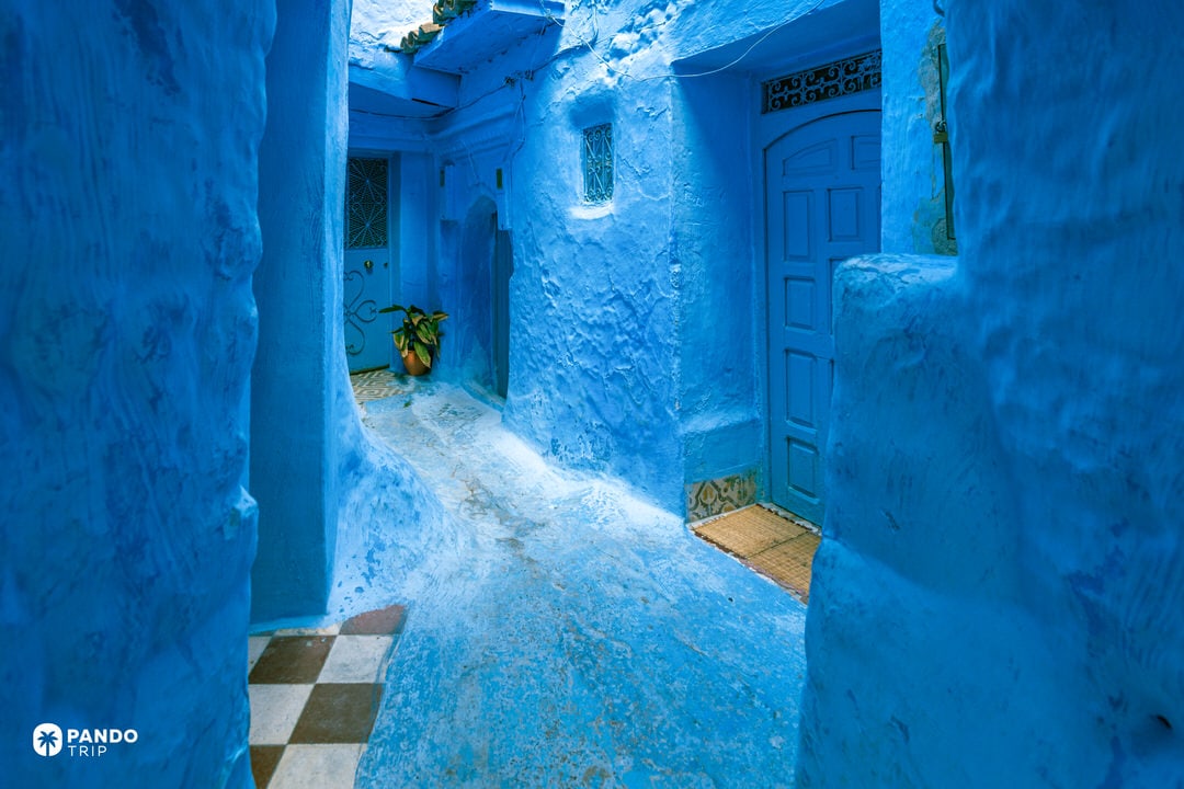 Curving blue alley with traditional doors in Chefchaouen, Morocco