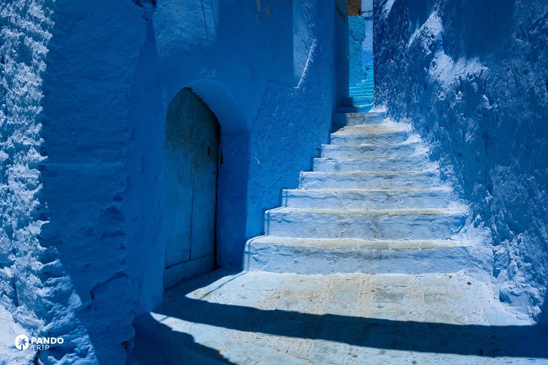 Steep blue staircase leading up a narrow alley in Chefchaouen