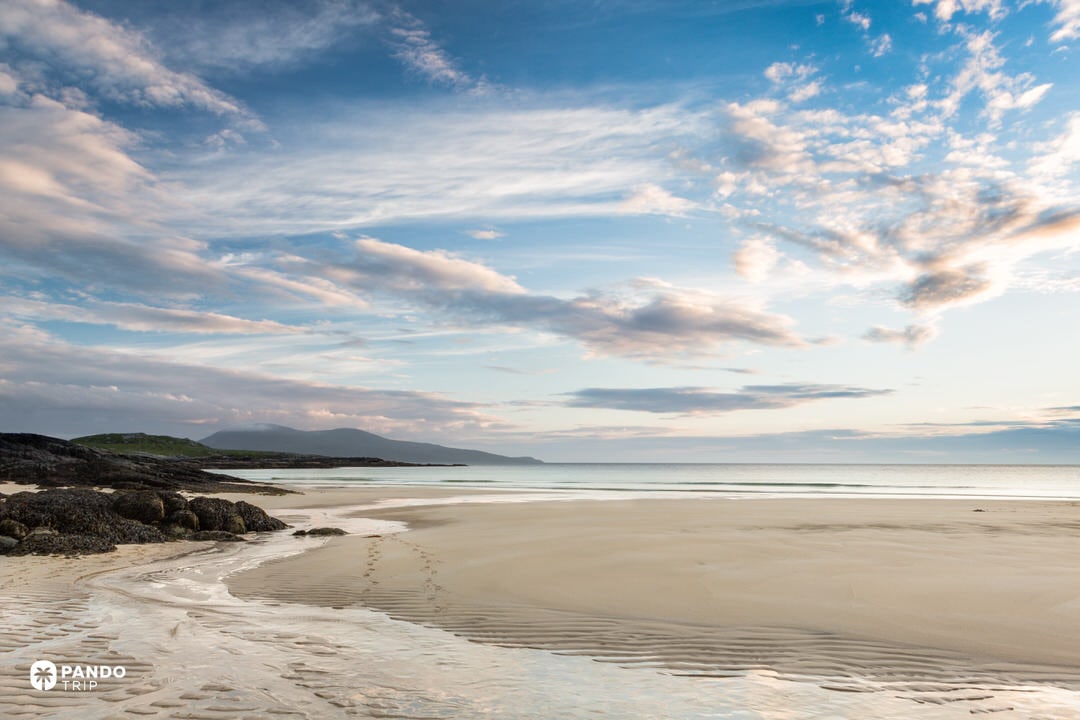 Horgabost bay and dunes with walkers on the path.