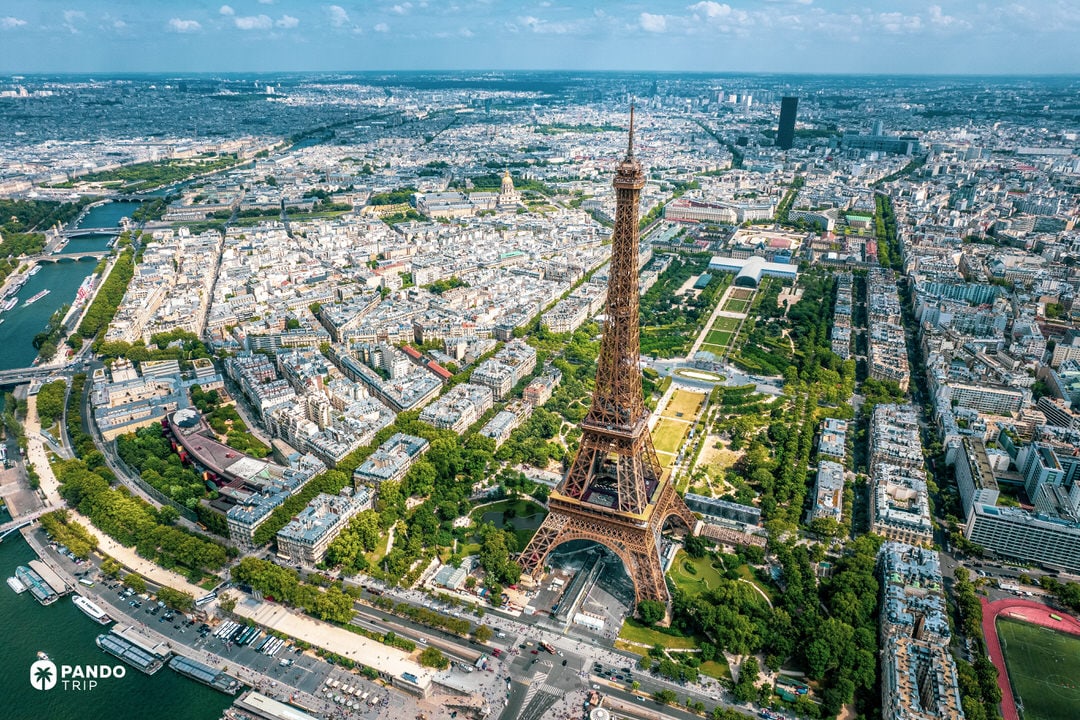 Aerial view of the Eiffel Tower in Paris with the Champ de Mars and the Seine River.