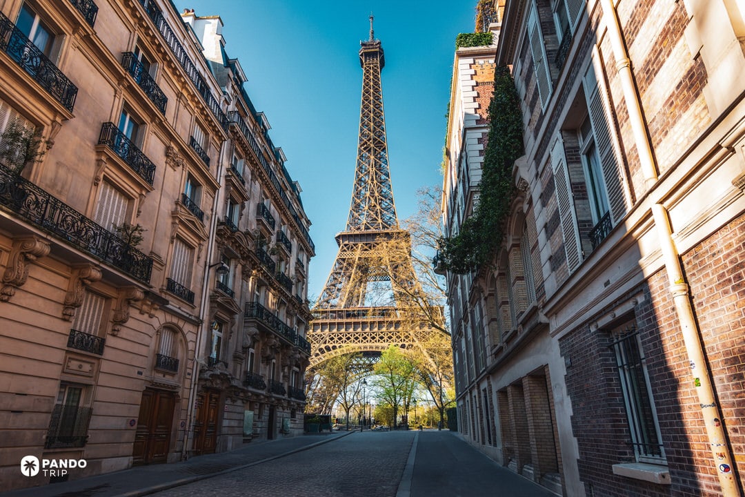 Eiffel Tower framed by Haussmann buildings on a quiet street in Paris’s 7th arrondissement.