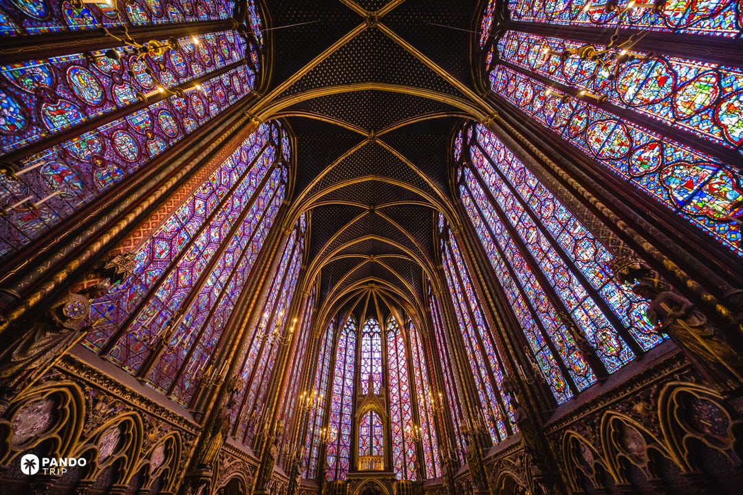 Interior of Sainte-Chapelle in Paris showing the upper chapel’s soaring Gothic vaults and stained-glass walls.