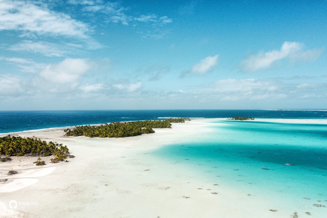 Aerial view of Rangiroa atoll and Blue Lagoon with palm-fringed motu in French Polynesia