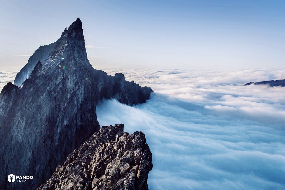 Jagged ridge of Troll Wall above a sea of clouds at sunrise