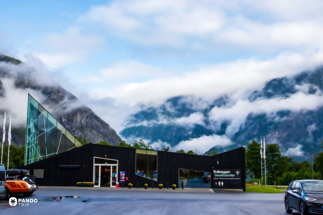 Modern Trollveggen Visitor Center with mountains and low cloud behind
